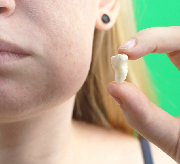 Woman holding dental floss near her mouth against green background for dental care demonstration.