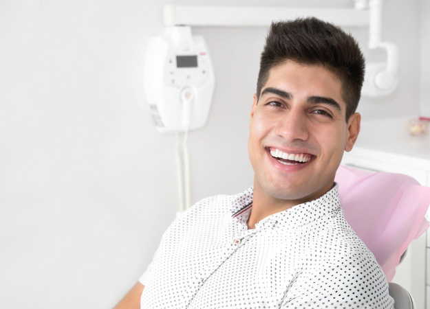 Young man smiling in dental chair at Dove Family Dentistry office during examination.
