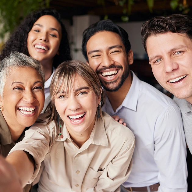 Diverse family group smiling together outdoors in casual clothing.