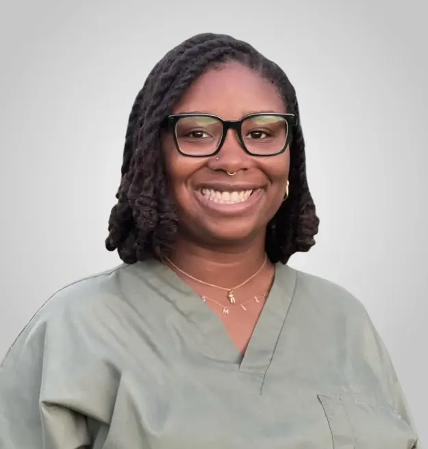 Dr. Christopher, dentist at Memphis dental practice, smiling professionally in medical scrubs.