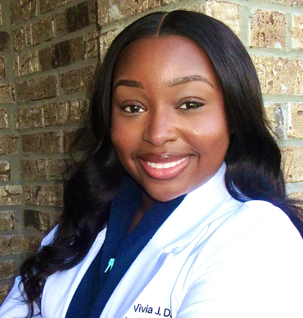 Dr. Davis, dentist at Memphis dental practice, poses professionally in white coat.