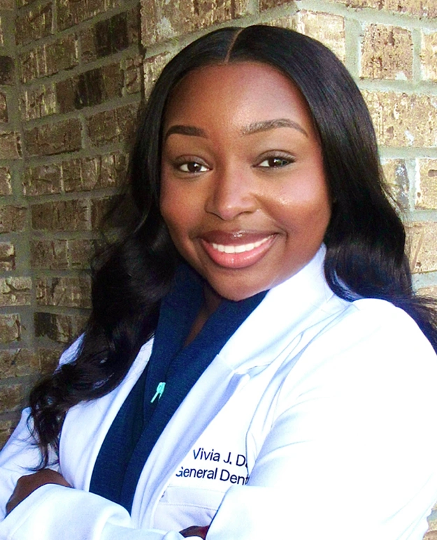 Dr. Vivia J. Davis, dentist at Memphis dental practice, smiling in professional white coat.