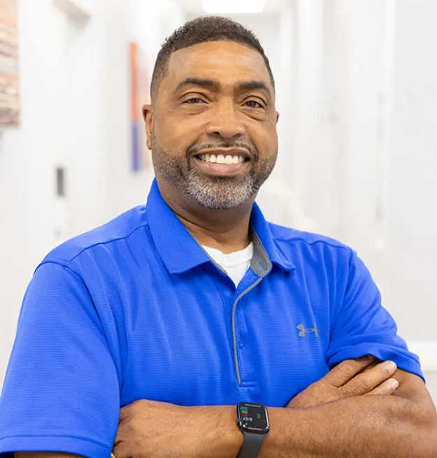 Dr. Anthony Polk, dentist at Memphis dental practice, smiling with arms crossed.
